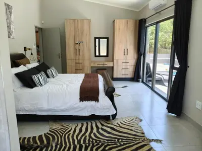 a bedroom with a bed and a zebra print rug at Eagle's Retreat in Marloth Park