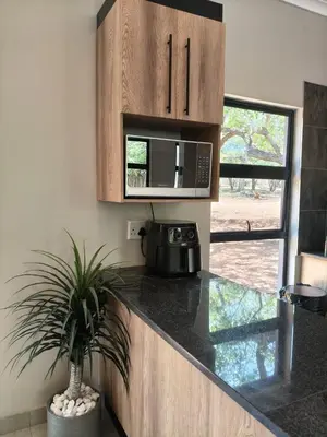 a kitchen with a counter top with a microwave at Eagle's Retreat in Marloth Park