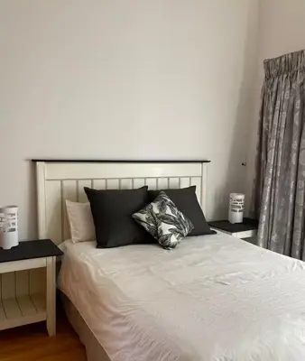 a bedroom with a white bed with black pillows at Oasis Nest in Pretoria