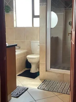 a bathroom with a toilet and a tub and a shower at Oasis Nest in Pretoria
