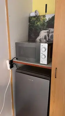 a microwave sitting on top of a refrigerator at Oasis Nest in Pretoria