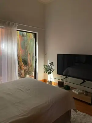 a bedroom with a bed and a flat screen tv at Oasis Nest in Pretoria