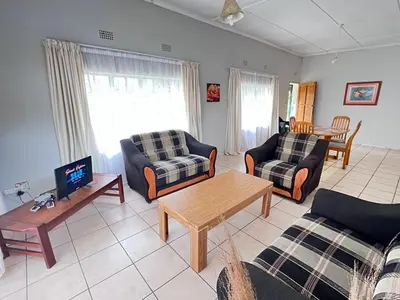 a living room with two couches and a tv at Nut Tree Nook in Hazyview