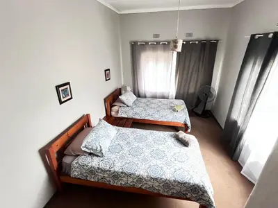 a bedroom with two beds and a window at Nut Tree Nook in Hazyview