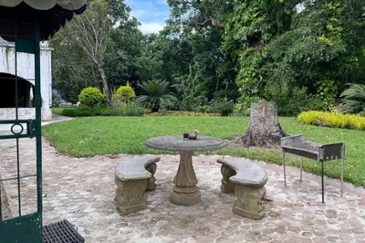 a stone table and two benches and a table and chairs at Nut Tree Nook in Hazyview