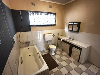 a bathroom with a tub and a toilet and a sink at Nut Tree Nook in Hazyview