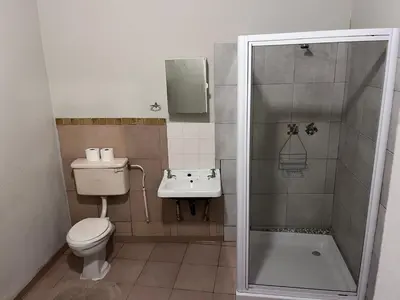 a bathroom with a shower and a toilet and a sink at Nut Tree Nook in Hazyview