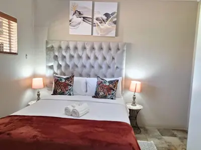 a bedroom with a large bed with two lamps at 270 Foutains Avenue, Centurion, Lyttelton Manor in Centurion