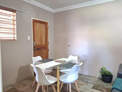 a dining room with a table and white chairs at 270 Foutains Avenue, Centurion, Lyttelton Manor in Centurion