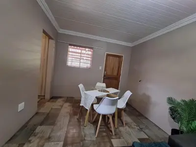 a dining room with a table and white chairs at 270 Foutains Avenue, Centurion, Lyttelton Manor in Centurion