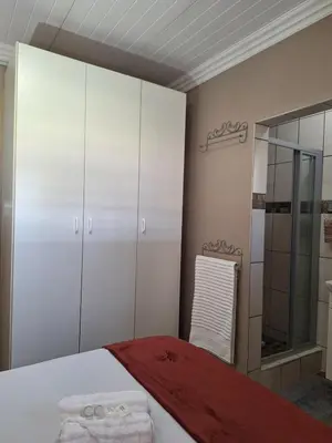 a bedroom with a bed and a glass shower at 270 Foutains Avenue, Centurion, Lyttelton Manor in Centurion