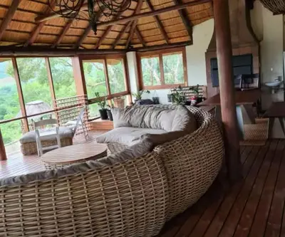 a living room with a large wicker couch on a wooden floor at RSM Country Estate Unit 2 in Nelspruit