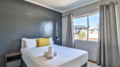 a bedroom with a large white bed with a window at Menlyn Place 506 in Pretoria