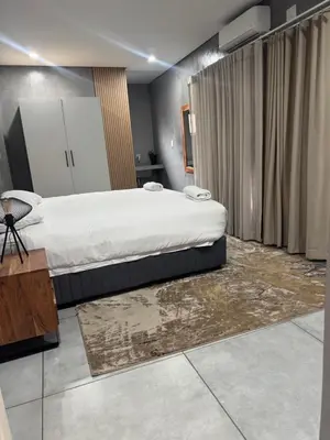 a bedroom with a large bed and a rug at Bras boutique in Steelpoort