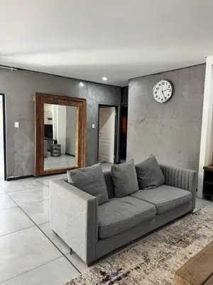 a living room with a couch and a mirror at Bras boutique in Steelpoort