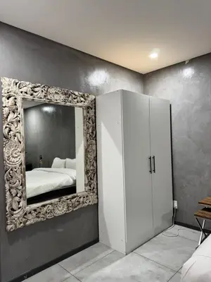 a bedroom with a mirror and a white cabinet at Bras boutique in Steelpoort