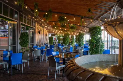 a restaurant with blue chairs and tables and a large room at Villa San Giovanni Accommodation in Pretoria