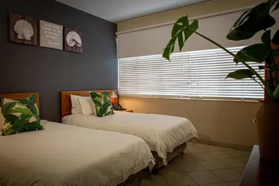 two beds in a room with a window at Villa San Giovanni Accommodation in Pretoria