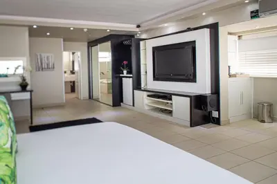 a living room with a flat screen tv on a wall at Villa San Giovanni Accommodation in Pretoria