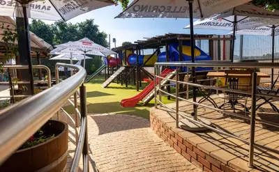 a park with a playground with tables and umbrellas at Villa San Giovanni Accommodation in Pretoria