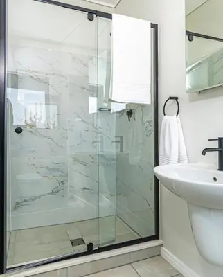 a bathroom with a glass shower and a sink at The Blyde Crystal Lagoon Pretoria in Pretoria