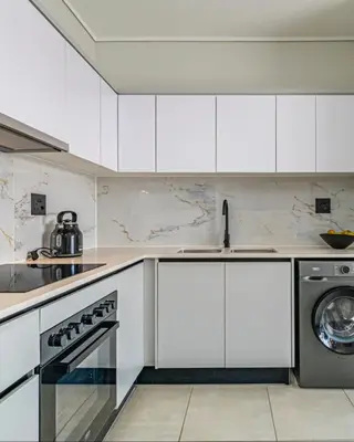 a kitchen with white cabinets and a dishwasher at The Blyde Crystal Lagoon Pretoria in Pretoria