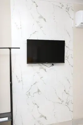 a flat screen tv hanging on a white wall at Lethabo Guesthouse