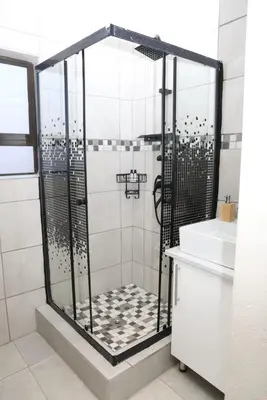 a shower stall in a bathroom with a sink at Lethabo Guesthouse