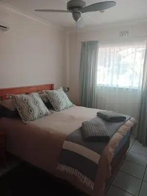 a bedroom with a bed with a ceiling fan and a window at The Roaches in White River