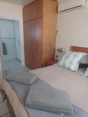 a bedroom with a large white bed with a wooden cabinet at The Roaches in White River