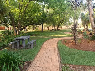 a picnic table and a bench in a park at Jireh in Pretoria