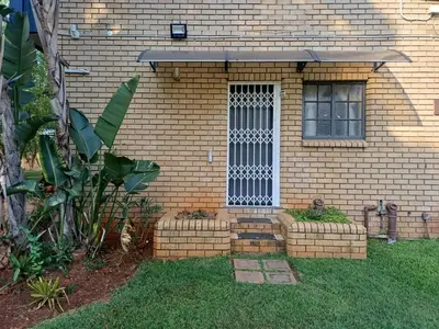 a brick house with a window in the yard at Jireh in Pretoria