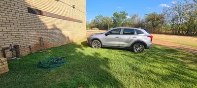a silver car parked in the grass next to a building at Jireh in Pretoria
