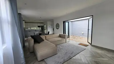a living room with a couch and a kitchen at Modern Farmhouse, Pool, AC, Wi-Fi in Estate in Hazyview