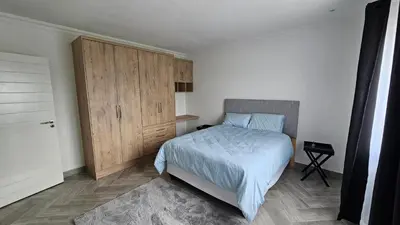 a bedroom with a bed and a wooden cabinet at Modern Farmhouse, Pool, AC, Wi-Fi in Estate in Hazyview