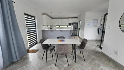 a kitchen and dining room with a table and chairs at Modern Farmhouse, Pool, AC, Wi-Fi in Estate in Hazyview
