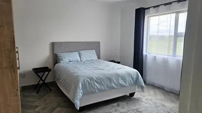 a bedroom with a bed and a window at Modern Farmhouse, Pool, AC, Wi-Fi in Estate in Hazyview