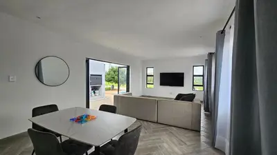 a living room with a table and a couch at Modern Farmhouse, Pool, AC, Wi-Fi in Estate in Hazyview