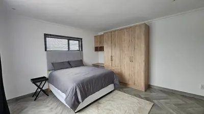 a bedroom with a bed and a wooden cabinet at Modern Farmhouse, Pool, AC, Wi-Fi in Estate in Hazyview