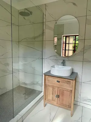 a bathroom with a sink and a mirror at Critchley Hackle - Deluxe garden units in Dullstroom