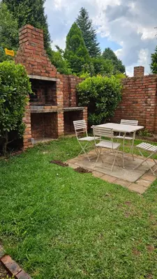 a picnic table and two chairs in a yard at Critchley Hackle - Deluxe garden units in Dullstroom