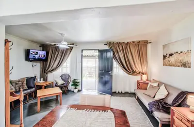 a living room with a couch and a table at Peaceful luxurious fully-equipped home in Centurion