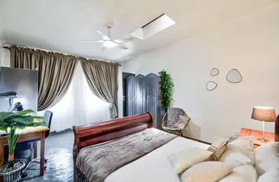 a bedroom with a bed and a desk at Peaceful luxurious fully-equipped home in Centurion