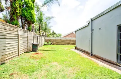 a backyard with a fence and a grass yard at Peaceful luxurious fully-equipped home in Centurion