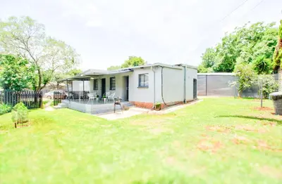 a small white house with a yard at Peaceful luxurious fully-equipped home in Centurion