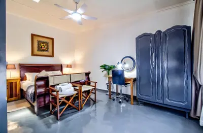 a bedroom with a bed and a desk with a desk at Peaceful luxurious fully-equipped home in Centurion