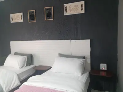 a bedroom with two beds and pictures on the wall at Comfort place 6 in Pretoria