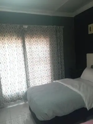 a bedroom with a bed and a window at Comfort place 6 in Pretoria