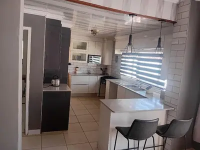a kitchen with a counter and chairs in it at Comfort place 6 in Pretoria