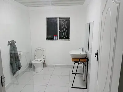 a white bathroom with a toilet and a sink at Comfort place 6 in Pretoria